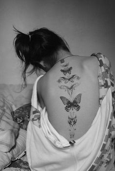 black and white photograph of a woman with butterflies on her back