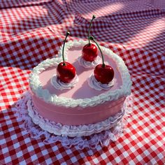 two cherries are placed on top of a cake