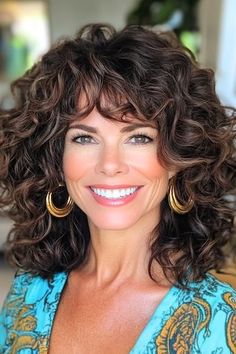 Save this pin for the best medium-length hairstyles for women over 50 with bangs. Voluminous curls bring life and energy to this shoulder-length style. The bouncy ringlets create a vibrant look that's perfect for women in their 50s. Hair With Bangs Over 50, Women In Their 50s, Medium Length Waves, Lob With Bangs