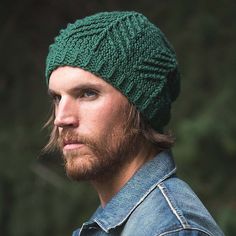 a man with a beard wearing a green knitted hat and looking off to the side