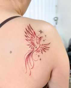 a woman's back shoulder with a red bird and stars tattoo on her left arm