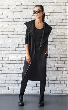 Long black sleeveless coat - METC0030 Inspired by urban style, this long casual vest is what your wardrobe needs to be extra cool! The shape of it is very modern allowing you to wear it alone as a sleeveless coat or over another piece as a long vest. This jacket gives you numerous ways of styling it with other clothing items. It is closed with clip buttons and has a statement collar. This item is both beautiful and very comfortable to wear. The coat is made of neoprene and polyester. WHEN YOU PL Long Black Vest, Neoprene Jacket, Oversize Coat, Long Black Cardigan, Statement Collar, Sleeveless Coat, Black Tunic Tops, Long Black Coat, Black Winter Coat