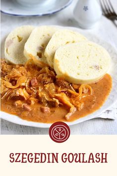 a white plate topped with bread and meat covered in gravy