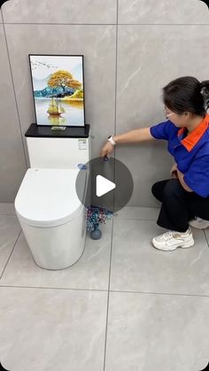 a woman kneeling down next to a white toilet