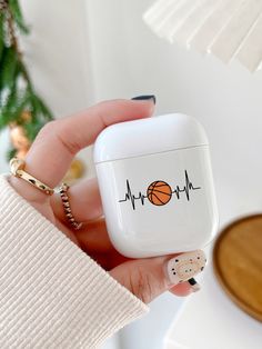 a person holding an apple airpods case with a basketball on the front and heartbeat