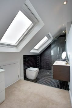 an attic bathroom with a skylight above the bathtub and sink area is shown