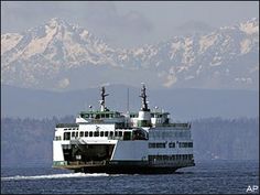 a large ferry boat in the water with mountains in the backgrounnds