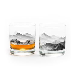 two shot glasses with mountains in the background