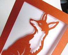 an orange and white greeting card with a cut out of a fox on it's side