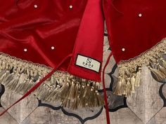 a red jacket with gold tassels on it and a label that says sale