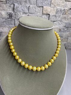 Gold Freshwater Pearl Necklace. This hand knotted strand features 47 Gold Freshwater Pearls AAA High Luster round 8.4-9.4 mm yellow overtones finished with a 8mm polished 14K Yellow Gold Filled bead clasp. This necklace measures 17 1/4 inches in length. I hand knotted this necklace with gold silk thread. These are genuine pearls, they are color enhanced, they are well matched with a few minor surface blemishes. The necklace pictured is the one you will receive, we hand craft our pieces one at a Yellow Gold High Luster Round Beads Necklace, Yellow Gold Necklace With High Luster Round Beads, Classic Gold Pearl Necklace With 8mm Beads, Yellow Gold Necklaces With 8mm Round Beads, Yellow Gold Necklaces With 8mm Beads, Classic Polished Beads Pearl Necklace, Classic Round Pearl Necklace With Polished Beads, High Luster Yellow Gold Pearl Necklace With Round Beads, Elegant Yellow Necklace With High Luster