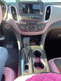 the interior of a car with pink trims and steering wheel, dash console, and center console