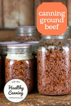 there are many jars with food in them on the table and an orange sign that says canning ground beef