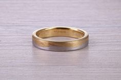 two tone gold wedding ring on wooden surface with copy space in the middle for text