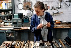 a woman is looking at some tools in a shop