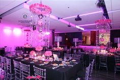 a room filled with lots of tables covered in black table cloths and centerpieces