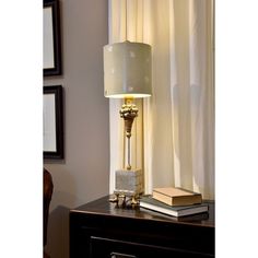 a lamp sitting on top of a wooden table next to a book and a chair