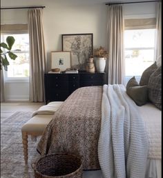 a bedroom with a large bed and two windows