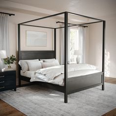 a four poster bed with white sheets and pillows