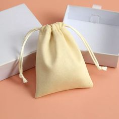 a small white bag sitting on top of a pink table