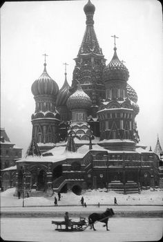 an old black and white photo of people walking in front of a building with domes