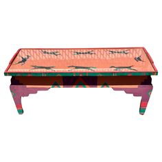 a pink table with birds painted on the top and bottom, sitting in front of a white background