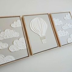 three framed pictures with white paper cutouts on them, each depicting a hot air balloon in the sky