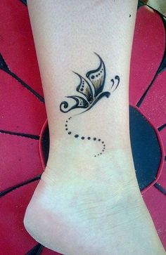 a black and white butterfly tattoo on the ankle