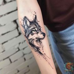 a woman's arm with a wolf tattoo on it