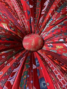 a close up view of a red umbrella with many different colors and patterns on it