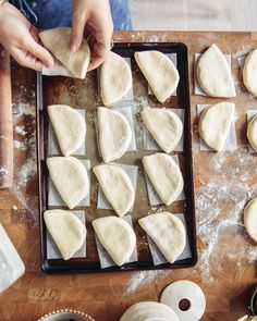 someone is making some kind of dough on a wooden table with other food items and utensils