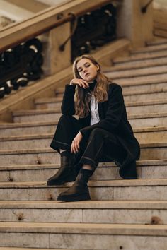 a woman is sitting on some stairs