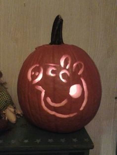 a carved pumpkin sitting on top of a table next to a stuffed animal and a teddy bear