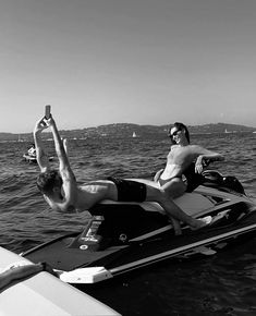 two people on a jet ski in the water with one person doing a hand stand