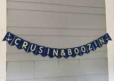 a blue and white banner that says cruise n & boozing hanging from the side of a house