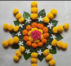 an arrangement of yellow and white flowers arranged in the shape of a flower