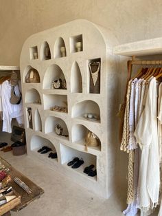 a room filled with lots of different types of shoes and clothing hanging on shelves next to each other