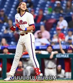 a baseball player holding a bat on top of a field in front of a crowd