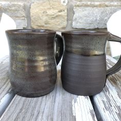 two coffee mugs sitting on top of a wooden table