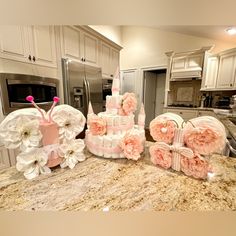 a kitchen counter topped with cakes covered in pink and white flowers next to an oven