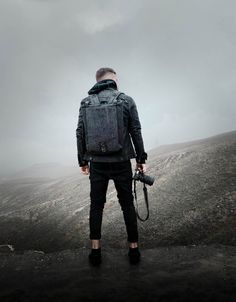 a man with a camera standing on top of a hill