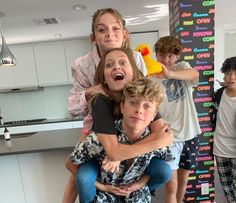 the kids are having fun in the kitchen with their mom and dad, who is holding him