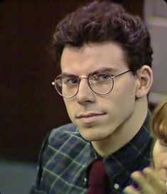 a man and woman sitting next to each other in front of a tv screen talking