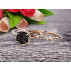 an engagement ring with a cushion cut black diamond in the center, surrounded by flowers