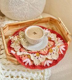 a cup of coffee sitting on top of a wooden tray next to a white teddy bear