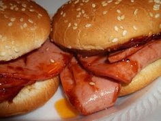 two hamburgers with meat and cheese are on a plate