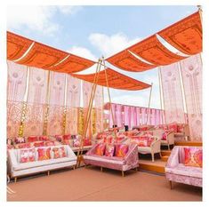 an outdoor seating area with pink and orange decor