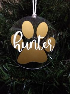 a glass ornament with a dog's paw and the word hunter on it