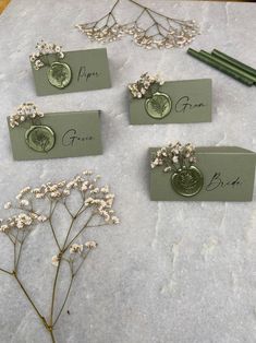 four place cards with flowers on them sitting on a table