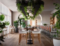 a restaurant with tables, chairs and plants hanging from the ceiling